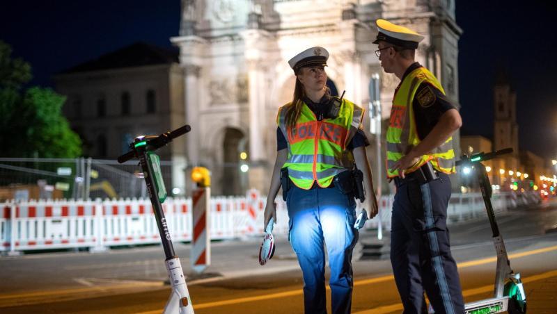 Polizisten stehen bei einer E-Tretroller-Kontrolle an der Straße. Polizisten stehen bei einer E-Tretroller-Kontrolle an der Straße.