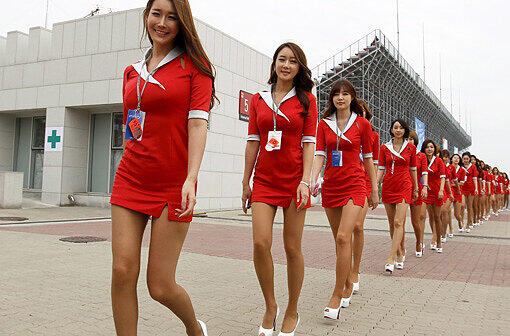 Attraktive Südkoreanerinnen marschieren zum Fahrerlager, um den Piloten ihren Aufenthalt zu versüßen. Sehen Sie die Bilder von den Boxenludern.