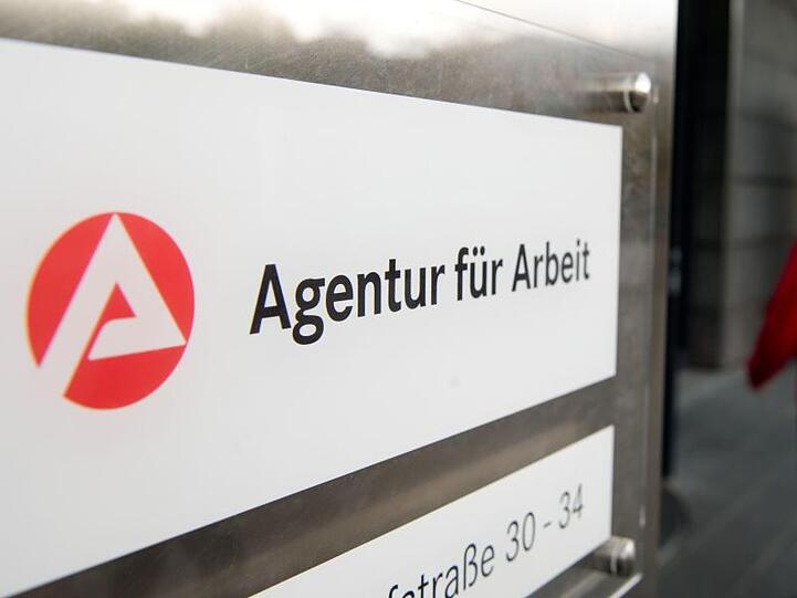 Ein Mann geht hinter dem Schild der Agentur für Arbeit zum Eingang. Foto: Sebastian Kahnert/Archiv