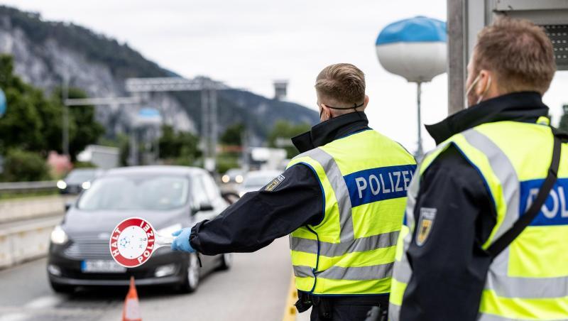 Deutsche Bundespolizisten beobachten an der Grenze zu Österreich auf der Autobahn A93 den Verkehr.