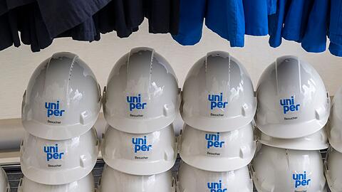 Helme mit der Aufschrift "Uniper" stehen während der Vorstellung des neuen Wasserstoffspeicher-Projekts HyStorage in Bierwang in einem Schrank.