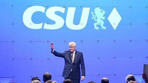 Der bisherige Parteivorsitzende Horst Seehofer winkt beim CSU-Sonderparteitag auf der Bühne. Foto: Tobias Hase