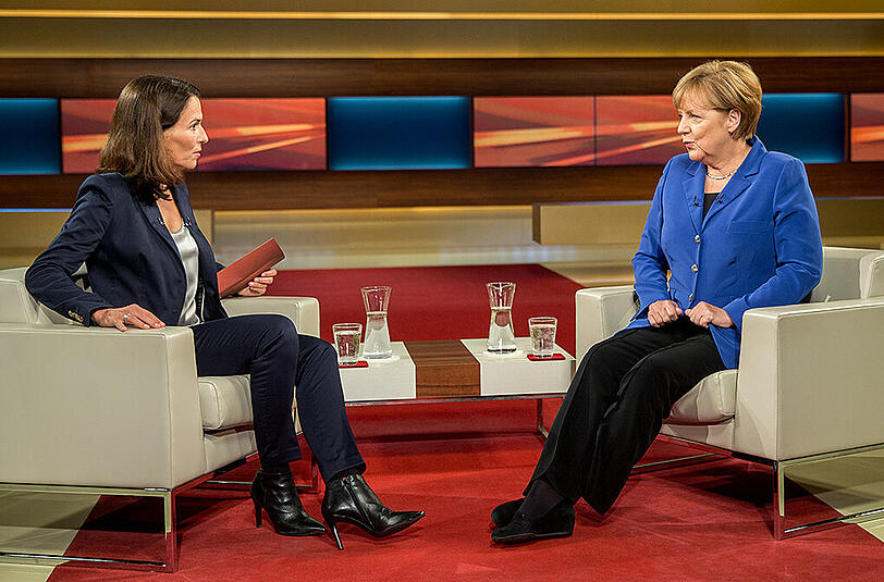 Bundeskanzlerin Angela Merkel (CDU) sitzt am 07.10.2015 TV-Moderatorin Anne Willgegenüber vor Beginn des TV Interviews im Studio in Adlershof in Berlin. In der TV-Talkshow spricht Merkel mit Will unter anderem über die aktuelle Flüchtlingskrise.