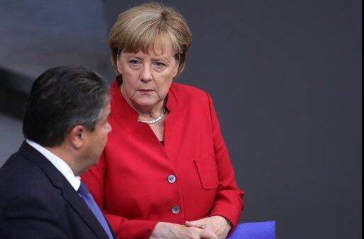 Kanzlerin Angela Merkel unterhält sich im Bundestag mit dem Bundeswirtschaftsminister und SPD-Vorsitzenden Sigmar Gabriel. Foto: Michael Kappeler/dpa
