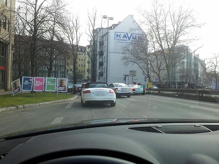 Per Mundpropaganda verbreitet sich die Idee: "Wir fahren einfach rückwärts raus!" Auch das ist verboten. Doch das kümmert jetzt keinen mehr. Rückwärtsgänge werden eingelegt, alle Autos wenden und fahren in umgekehrter Richtung die Blumenstraße entlang. Die Polizisten stehen staunend daneben. Einer versucht, den Korso zu stoppen. Vergeblich.