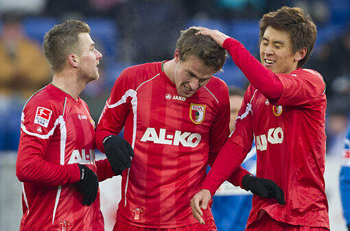 Augsburgs Torschütze Sebastian Langkamp (Mitte) freut sich mit Daniel Baier (links) und Ja-Cheol Koo über sein Tor zum 2:2.