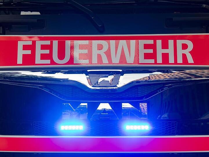 Ein Einsatzfahrzeug der Feuerwehr mit angeschaltetem Blaulicht. Foto: Paul Zinken/dpa/Symbolbild