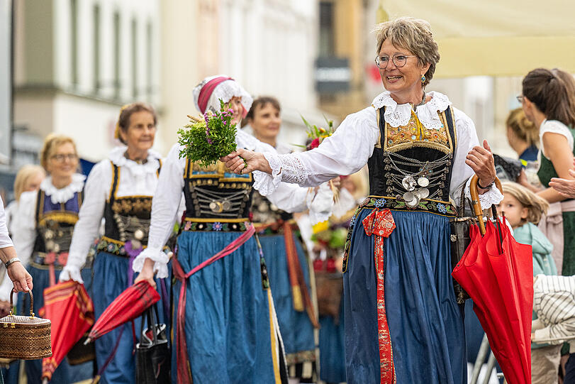 Teilnehmer des traditionellen Auszugs zum Gäubodenvolksfest gehen in Tracht durch die Innenstadt.