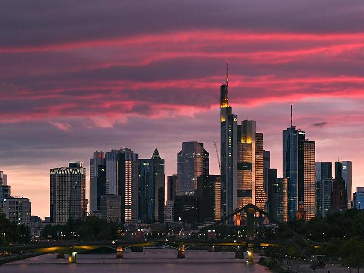 Bei Sonnenuntergang ist die Skyline der Bankenstadt in rötliches Licht getaucht.