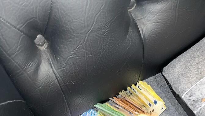 Bargeld, versteckt unter den Kissen des Sofas.