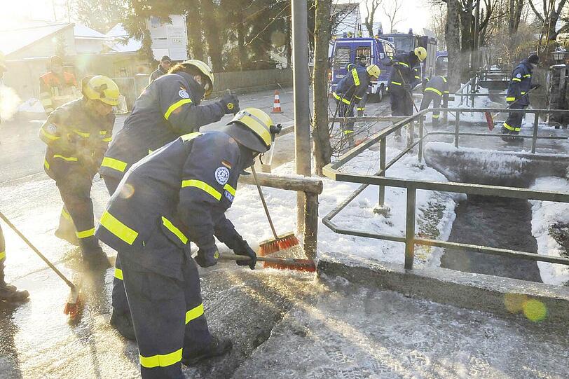 Eiskratzen im größeren Stil: Die Helfer befreien eine Straße von Eis. Der Hachinger Bach war übergelaufen