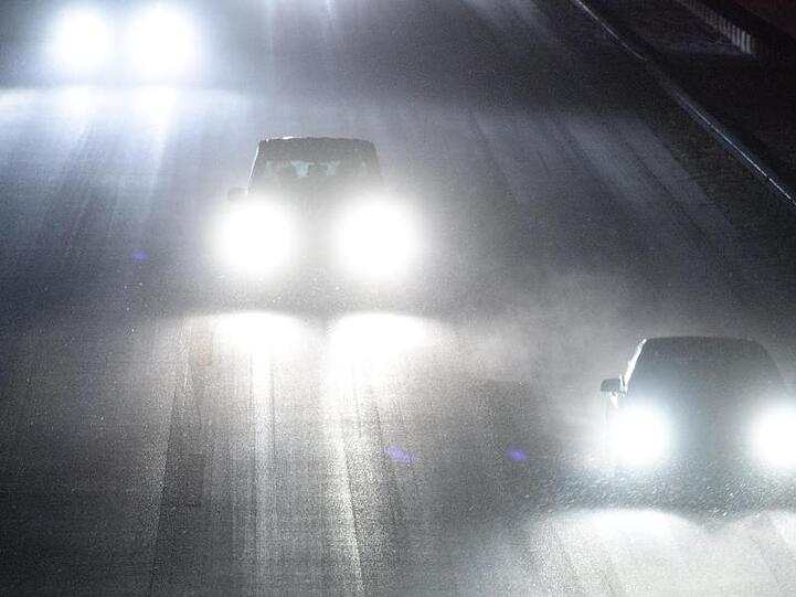 Autos fahren über die verschneite Autobahn 8 bei Sauerlach. Foto: Matthias Balk
