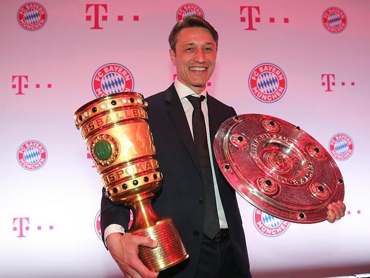 Bayern-Trainer Niko Kovac hält mit dem DFB-Pokal und Meisterschale.