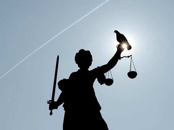 Justitia mit Sonne und Taube. Foto: Arne Dedert/dpa/Symbolbild