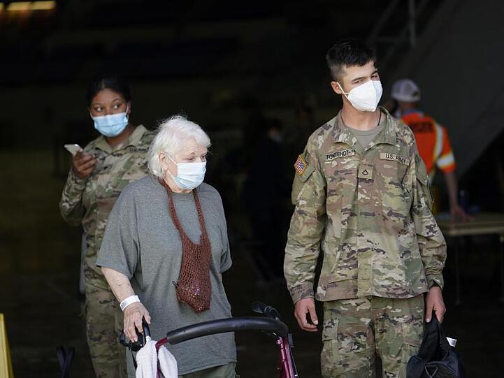 Eine ältere Frau wird in Lake Charles, Louisiana, während der Evakuierung von einem Soldaten begleitet.