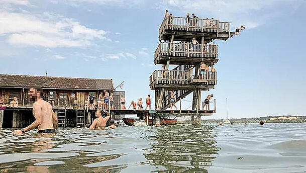 Badeg&auml;ste springen vom Turm im Strandbad Utting.