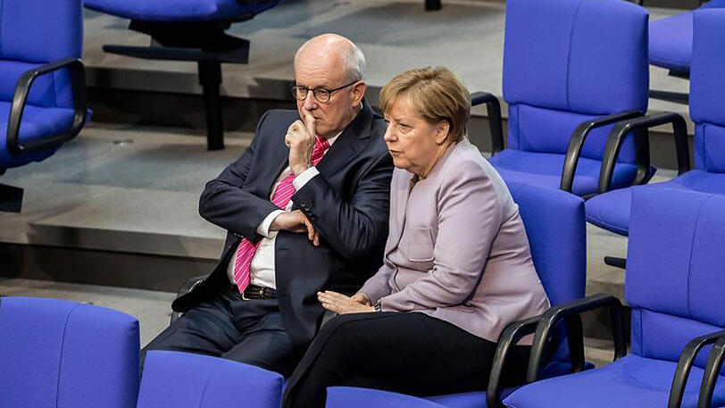 Bundeskanzlerin Angela Merkel und Unions-Fraktionschef Volker Kauder unterhalten sich im Bundestag in Berlin.