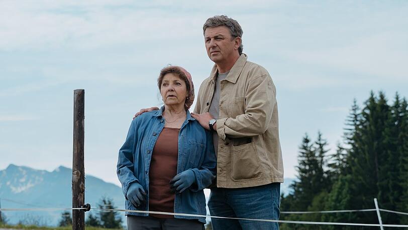 "Der Bergdoktor: H&ouml;henflug": Dr. Martin Gruber (Hans Sigl, r.) und Lisbeth Gruber (Monika Baumgartner) beobachten, wie ein Segelflugzeug auf ihrer Wiese notlanden muss.