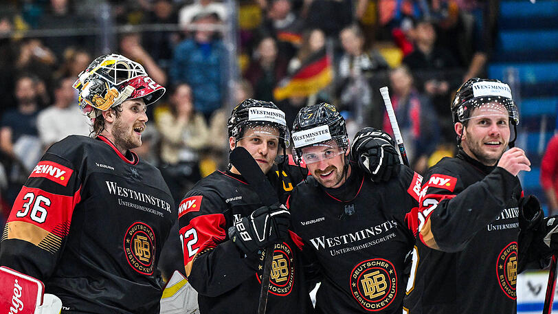 Leon Hungerecker, Dominik Kahun, Maximilian Kastner und Parker Tuomie (v.l.) freuen sich nach Spielende &uuml;ber den Sieg &uuml;ber &Ouml;sterreich im Garmischer Olympia-Eissportzentrum.