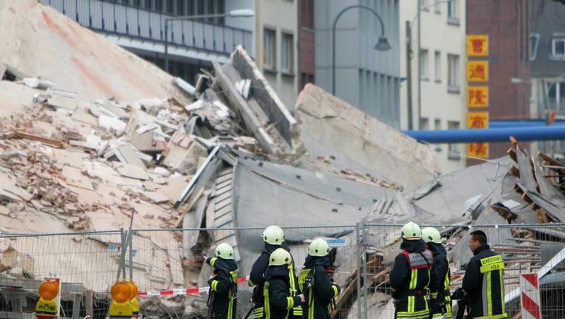 Der Trümmerhaufen: Rettungskräfte stehen vor den Überresten der zerstörten Gebäude. Der Trümmerhaufen: Rettungskräfte stehen vor den Überresten der zerstörten Gebäude.