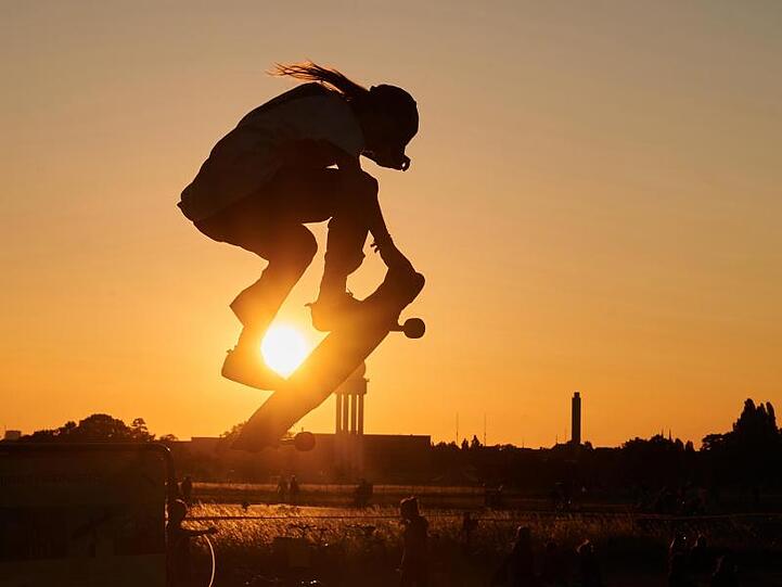 Ein Skater springt mit seinem Skateboard in die Luft.