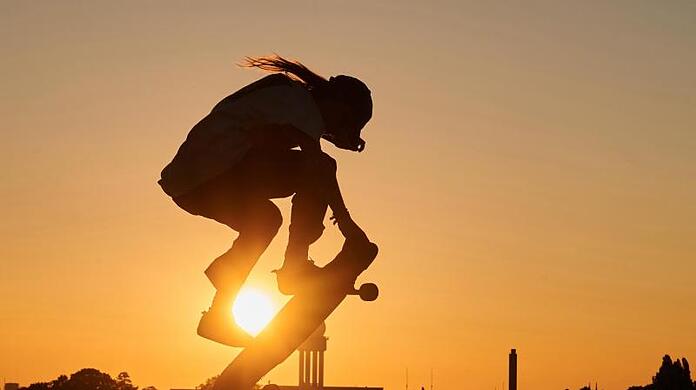 Ein Skater springt mit seinem Skateboard in die Luft.