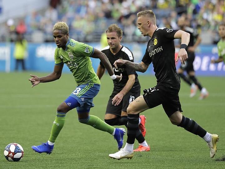 Joevin Jones von den Seaattle Sounders (l) wird von den BVB-Spielern Marius Wolf (r) und Mario Götze attackiert.