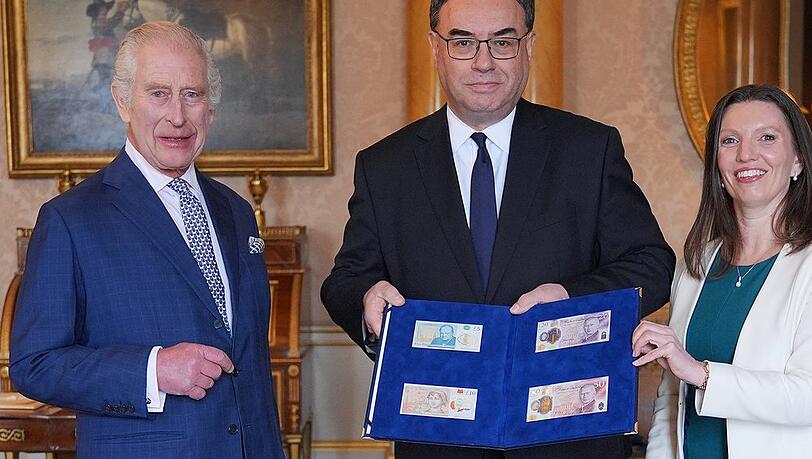 König Charles III. mit dem Gouverneur der Bank of England, Andrew Bailey, und den neuen Banknoten.