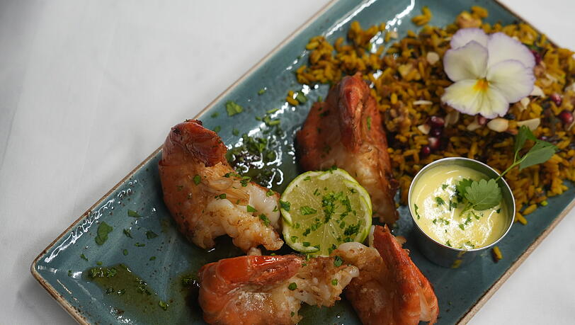 Scampi Antillaise vom Grill, flambiert mit Rum, Tamarinden-Reis und Safran-Wei&szlig;wein-So&szlig;e.