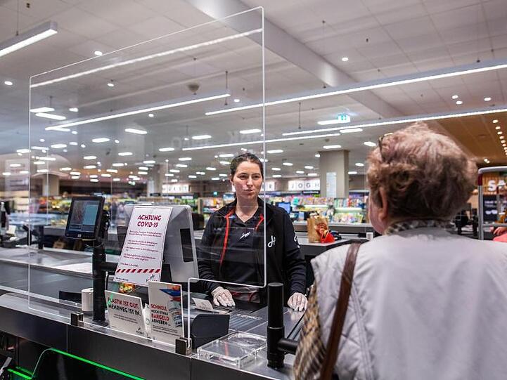 In einem Supermarkt in Rheinfelden in Baden-Württemberg wird die Kassiererin von einer Plexiglasscheibe geschützt.