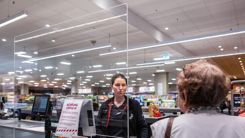 In einem Supermarkt in Rheinfelden in Baden-Württemberg wird die Kassiererin von einer Plexiglasscheibe geschützt. In einem Supermarkt in Rheinfelden in Baden-Württemberg wird die Kassiererin von einer Plexiglasscheibe geschützt.