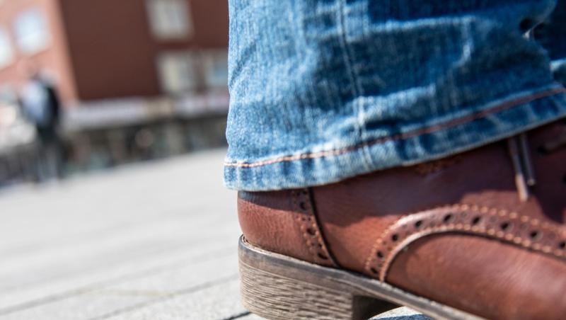 Eine Frau versucht mit ihrem Schuh nicht auf ein altes ausgespucktes Kaugummi zu treten. Eine Frau versucht mit ihrem Schuh nicht auf ein altes ausgespucktes Kaugummi zu treten.