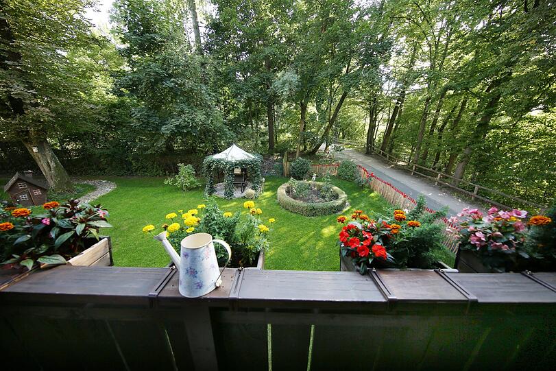 Vom Balkon im ersten Stock schaut der Besucher in den schönen Garten.