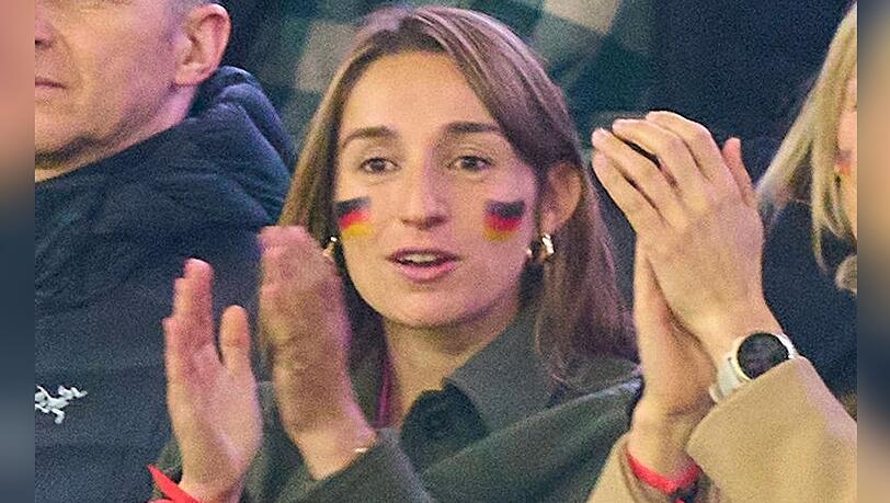 Lena Wurzenberger mit Deutschlandfahne im Gesicht und dem pinken Trikot unter ihrer Jacke beim Spiel gegen die Niederlande.