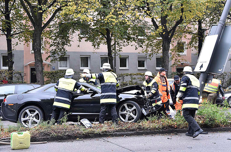 Einsatzkräfte an der Unfallstelle. Der Chevrolet Camaro war auf dem Mittleren Ring gegen einen Laternenmasten geprallt.