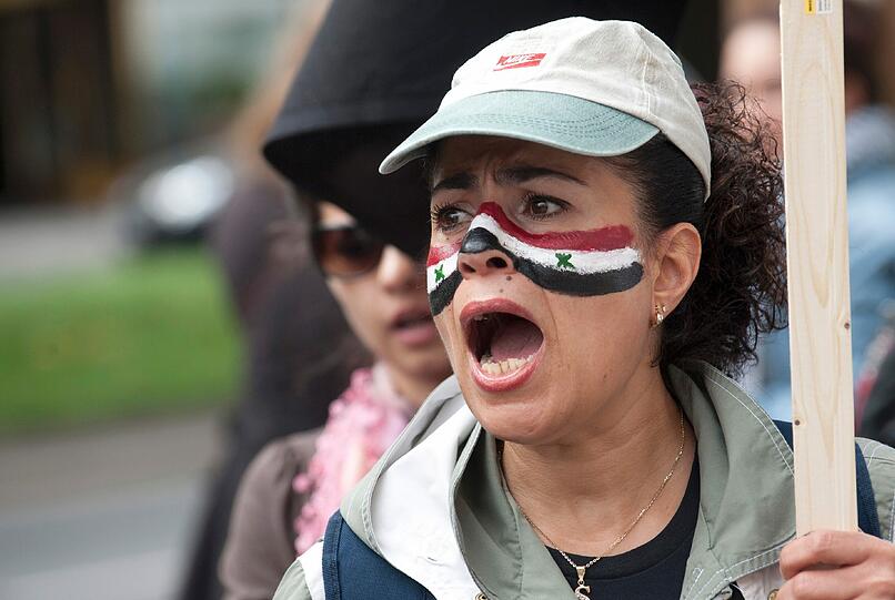 Ob die Erlaubnis politischer Parteien in Syrien die Lage im Land verbessern wird, bezweifeln Berater. Im Bild: Die Teilnehmerin einer Kundgebung in Berlin demonstriert am Samstag (23.07.11) für Freiheit und Demokratie in Syrien. Sie hat die syrische Flagge ins Gesicht gemalt.