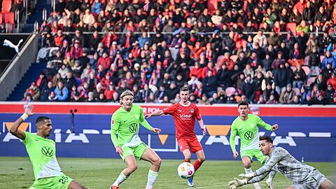 Wolfsburgs Moritz Jenz (l) traf beim 1:1 in Heidenheim ins eigene Tor.