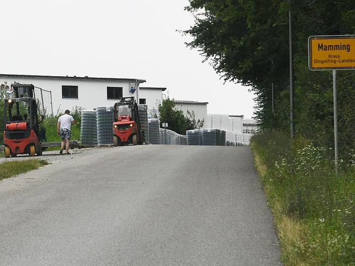 Arbeiter errichten einen Zaun um die Wohngebäude eines Betriebes in Mamming. Foto: Angelika Warmuth/dpa/Archivbild