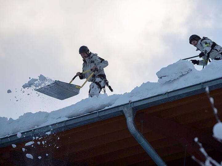 Kräfte der Bundeswehr räumen das Dach der Watzmann-Therme in Berchtesgaden vom Schnee. Foto: Lino Mirgeler