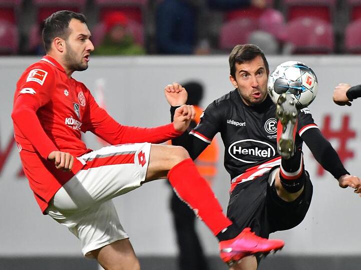 Der Mainzer Levin Ötztunali (l) und Düsseldorfs Markus Suttner kämpfen um den Ball.
