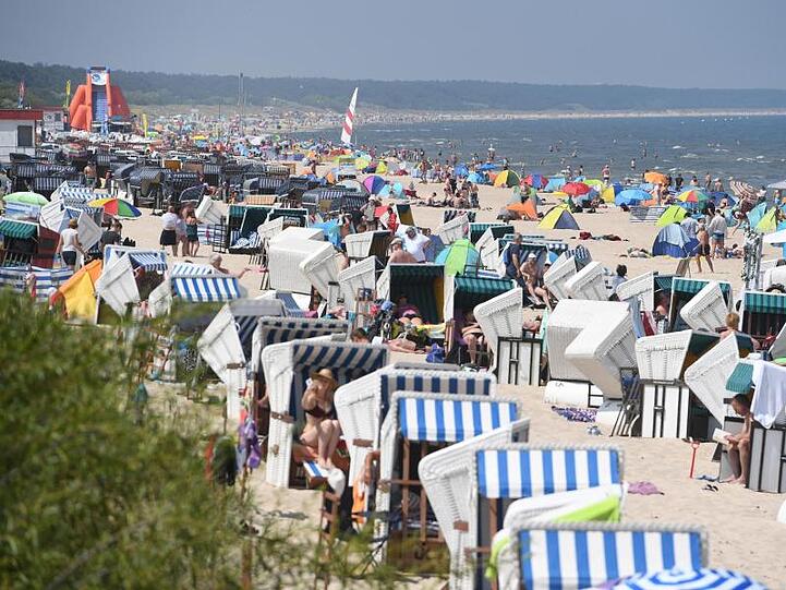 Touristen strömen bei hochsommerlichem Wetter an den Strand auf der Insel Usedom.