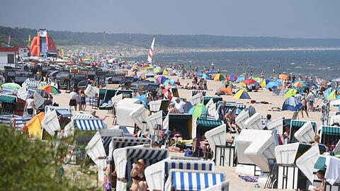 Touristen strömen bei hochsommerlichem Wetter an den Strand auf der Insel Usedom.