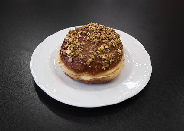 Der Krapfen ist &uuml;bers&auml;t mit ger&ouml;steten Pistazien.