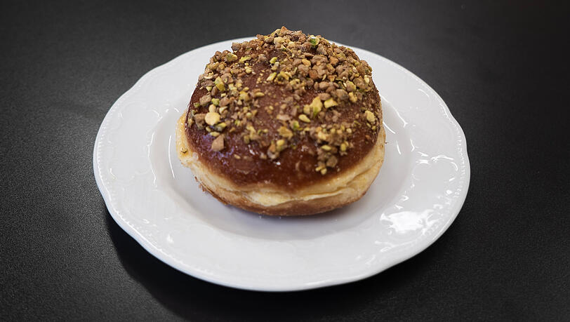 Der Krapfen ist &uuml;bers&auml;t mit ger&ouml;steten Pistazien.