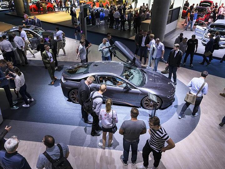 Besucher der IAA schauen sich auf dem Messestand von BMW um.