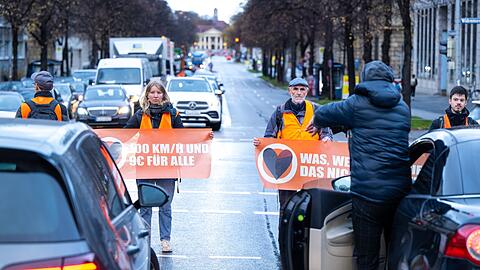 Mitglieder der Umweltschutzbewegung "Letzte Generation" blockieren eine Straße.