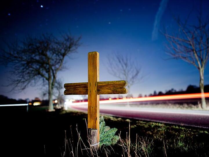 Ein Kreuz zur Erinnerung an einen Verkehrstoten steht an einer Landstraße. Foto: Julian Stratenschulte/dpa/Archivbild