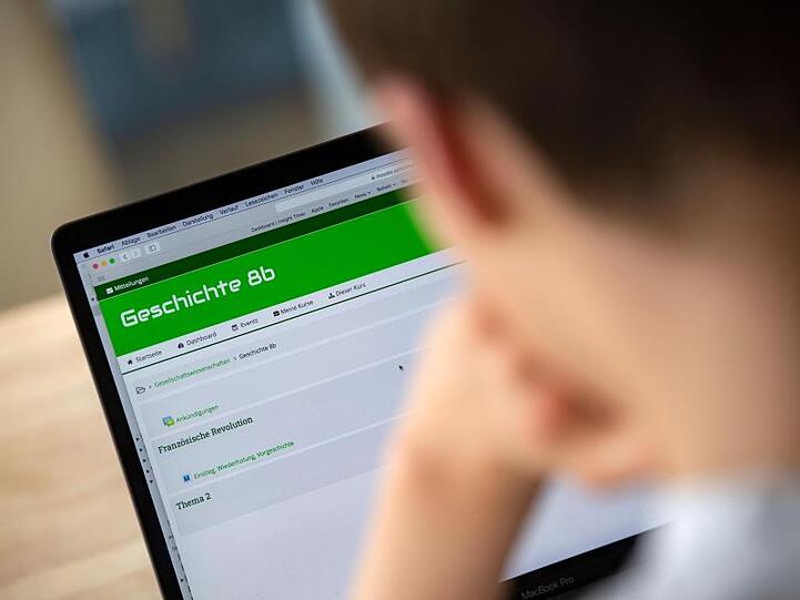 Ein Schüler, der in die 8. Klasse eines Gymnasiums geht, bedient an einem Notebook die Lernplattform Moodle.