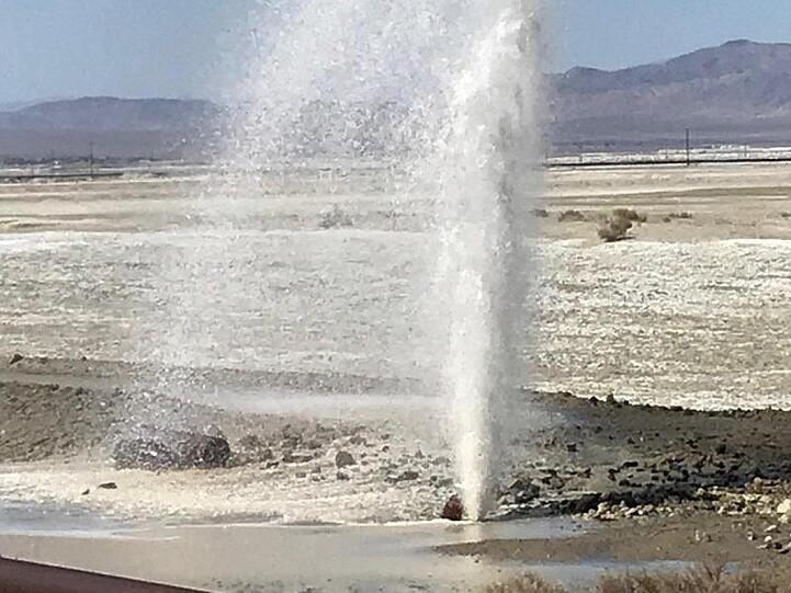 Wasser sprudelt aus einem scchwer beschädigten Rohr.