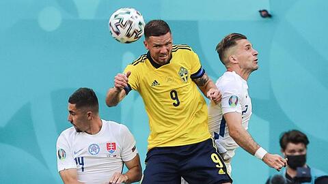 Schwedens Marcus Berg steigt zwischen den Slowaken Martin Koscelnik (l) und Peter Pekarik (r) zum Kopfball hoch.